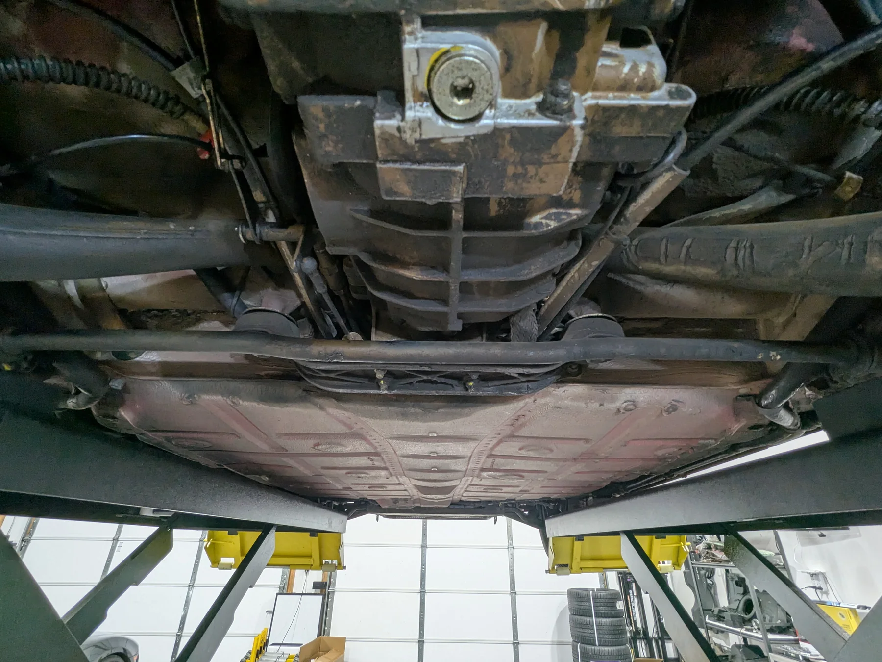 Before dry ice cleaning: engine, transmission, suspension, and exhaust-adjacent underside detail of the 1988 Porsche 911