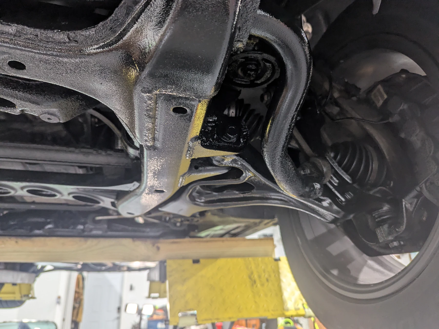 Before lanolin undercoating: opposite front wheel-side control arm and subframe of the 2013 Porsche Cayenne