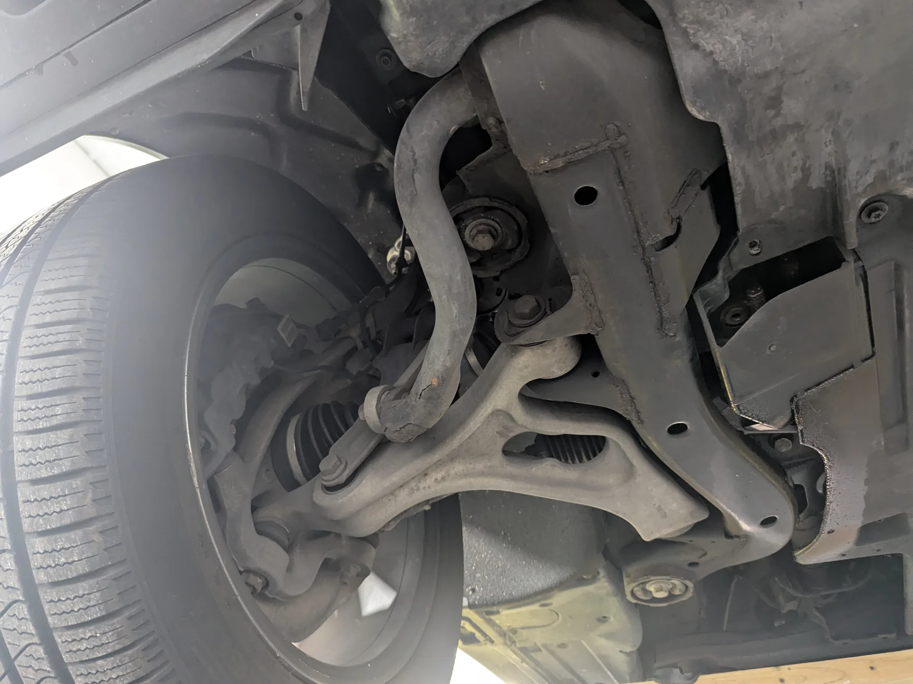 After lanolin undercoating: matching front wheel-side control arm, sway bar, and protected subframe of the 2013 Porsche Cayenne