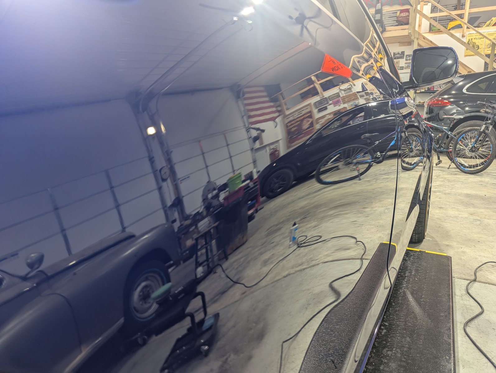 Blue Cadillac ATS side panel during two stage paint polishing with clear reflections